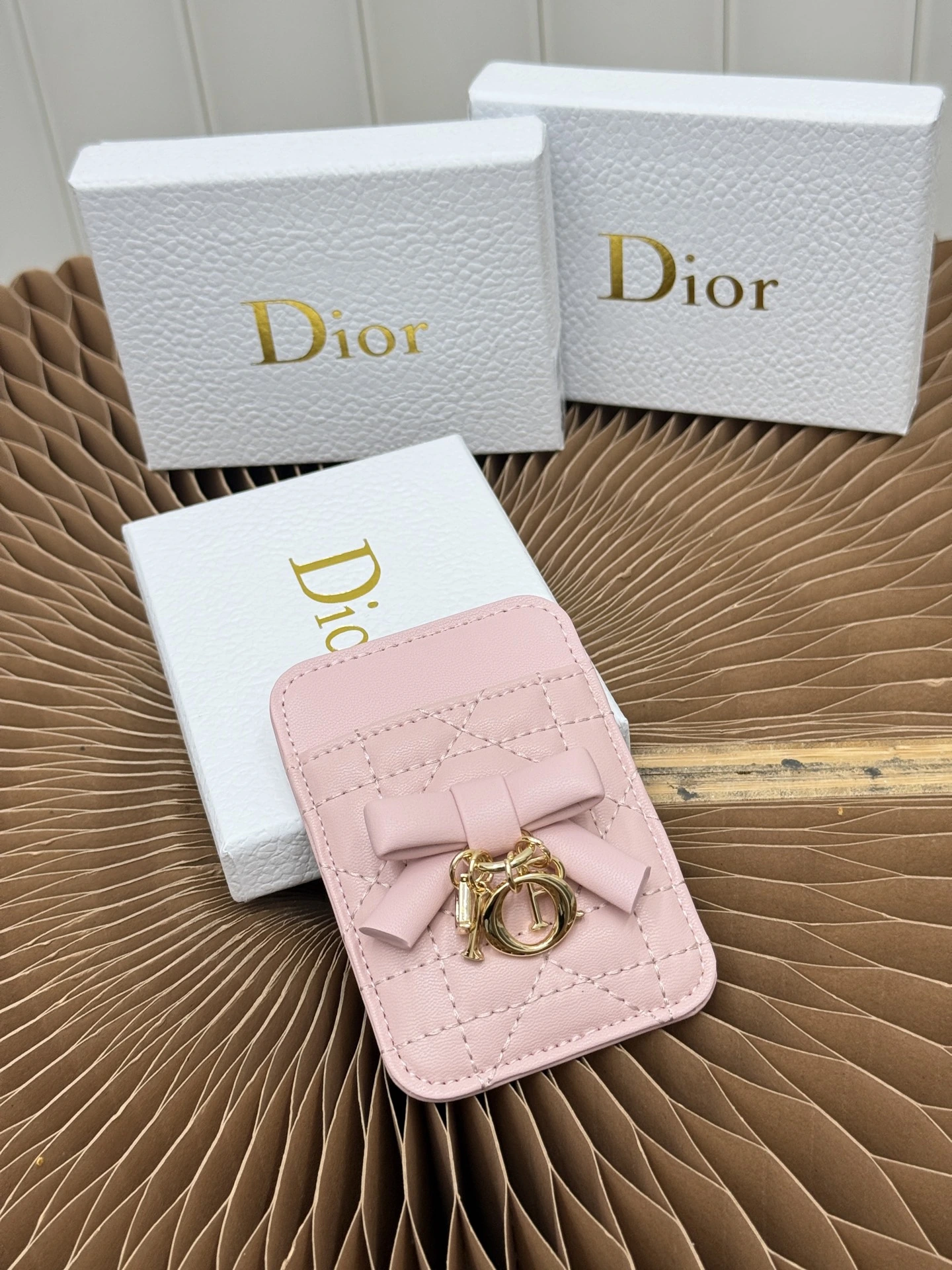 このLady Dior（ディオール / Dior）マグネットカードホルダーは精巧なアクセサリーで、ブランドの卓越したクラフツマンシップを表現します ピンクのCannageキルティング柄ラムスキンに精巧なリボンをあしらい、Dior（ディオール / Dior）の新たなアイコンとして工房の技術を示します