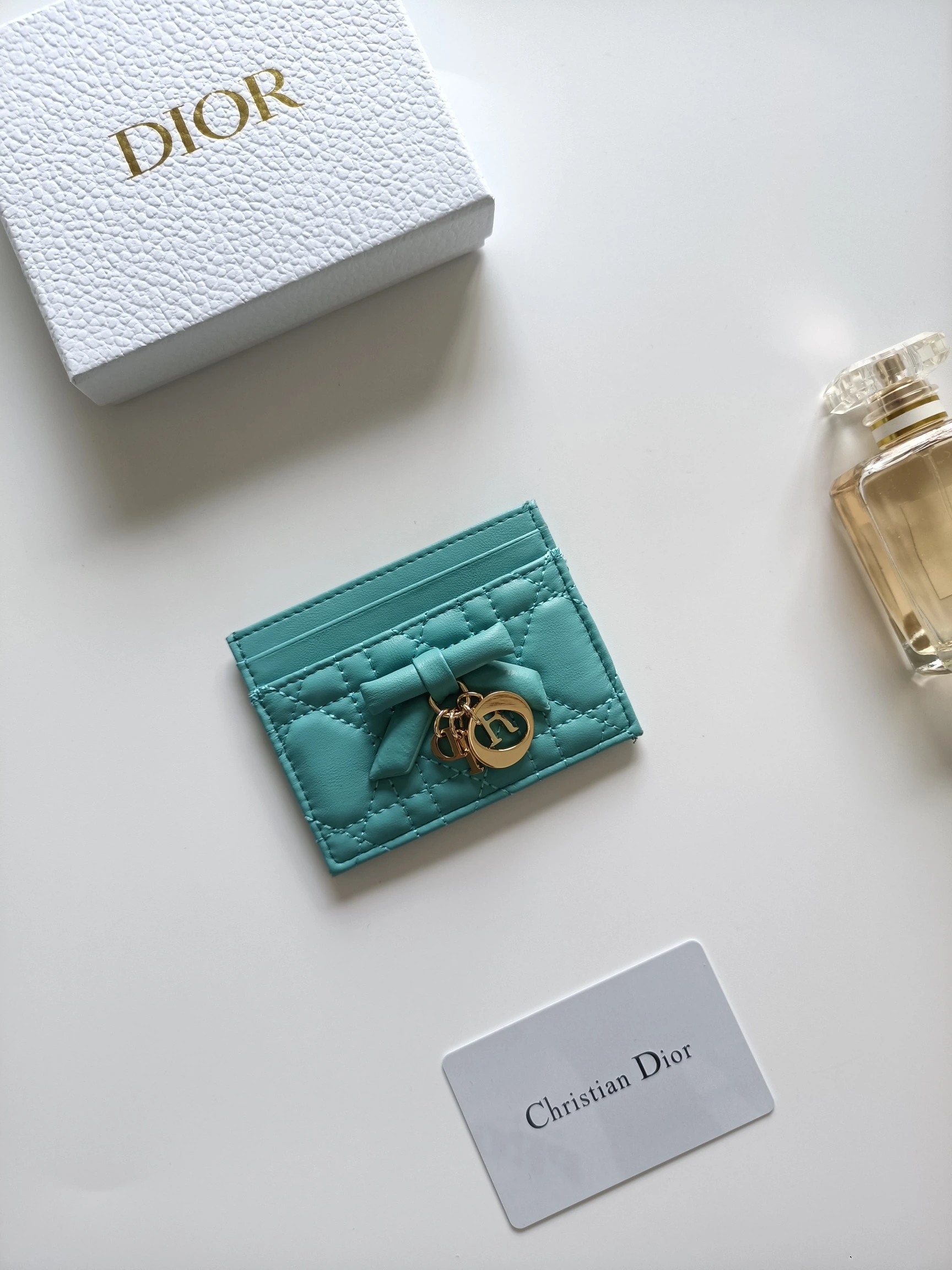 ディオールの最新作、商品番号:S2604 サイズ:10.5×8×0.5cm この「Lady Dior Freesia」カードケースは、エレガントで実用的なアクセサリーです。淡いピンク(Soupir pink)とクリーム色のツートンカラーで、ラムレザーを丁寧に仕立て、カギ目模様のステッチが施されています。前面には装飾用のレザーリボンがアクセントとなり、シルバー