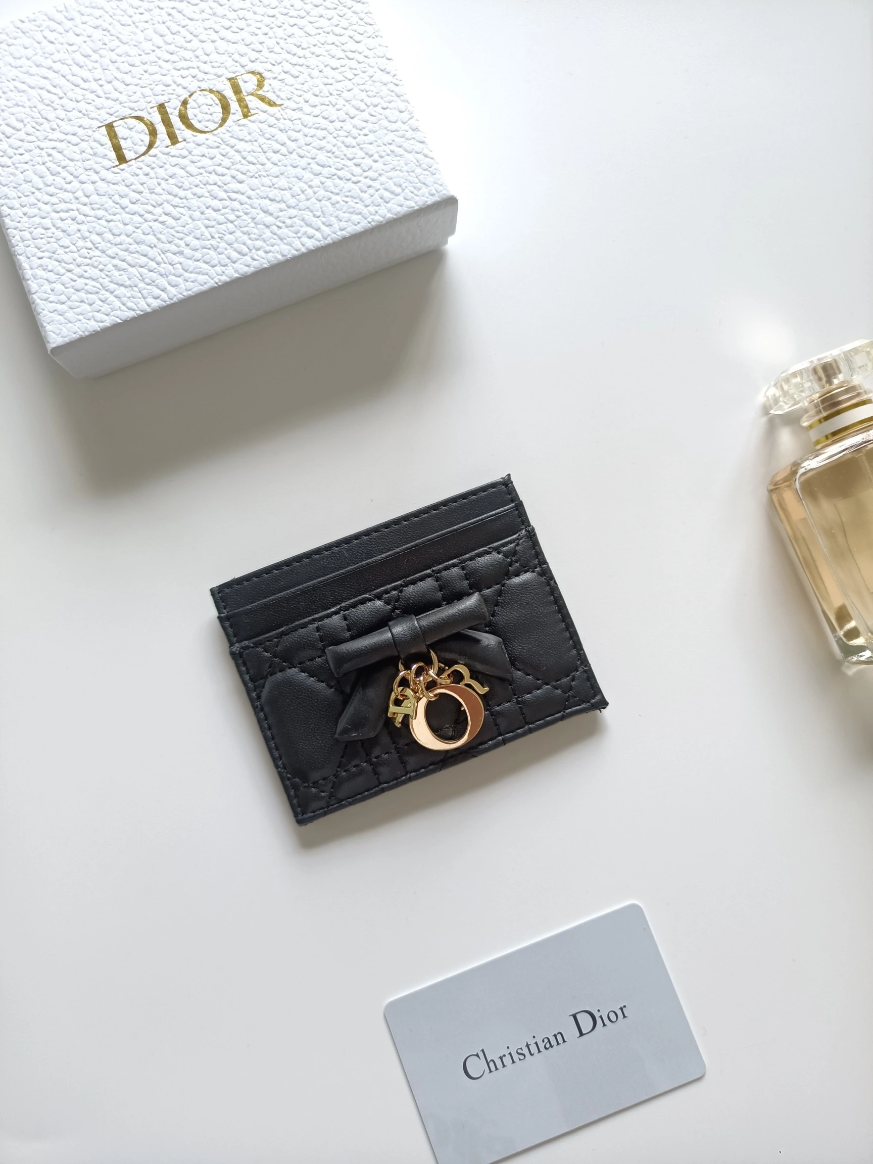 ディオールの最新作、商品番号:S2604 サイズ:10.5×8×0.5cm この「Lady Dior Freesia」カードケースは、エレガントで実用的なアクセサリーです。淡いピンク(Soupir pink)とクリーム色のツートンカラーで、ラムレザーを丁寧に仕立て、カギ目模様のステッチが施されています。前面には装飾用のレザーリボンがアクセントとなり、シルバー
