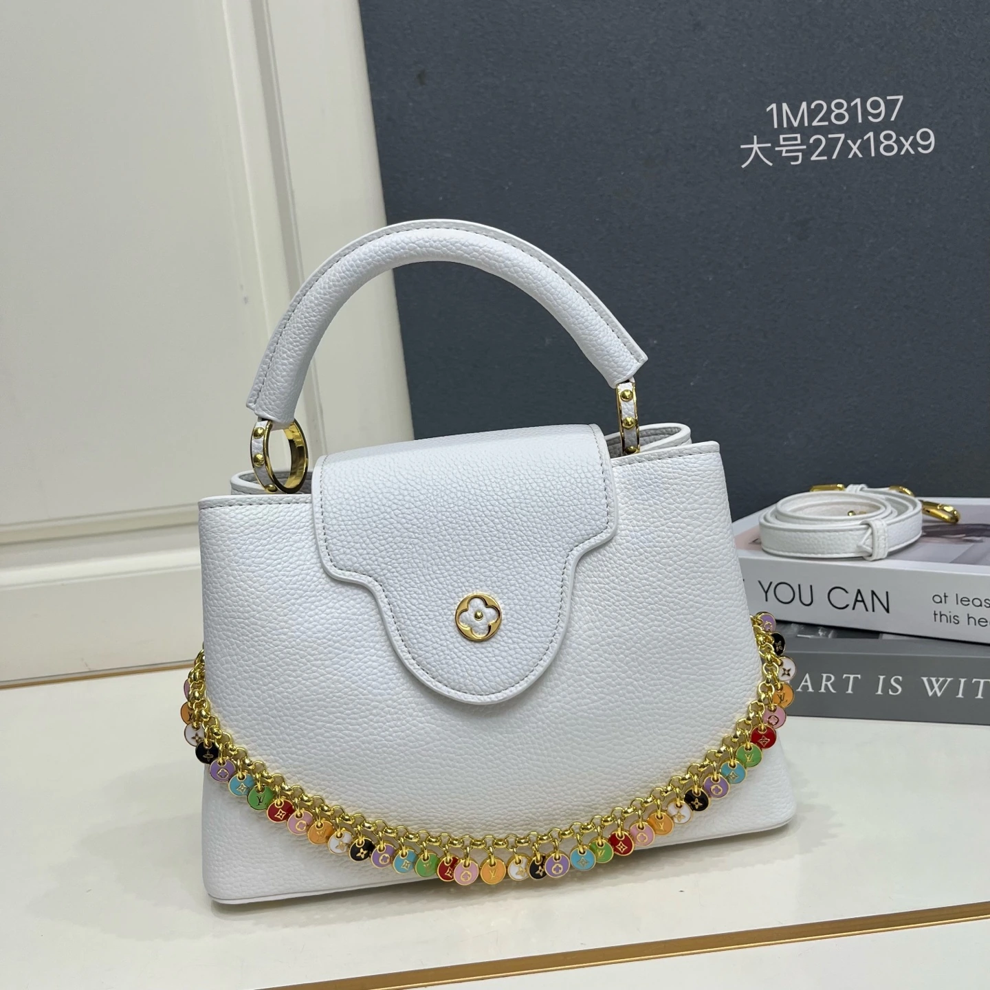 ラージサイズの1M28197 カプシーヌBBバッグは、柔らかな色合いでLVコンフェッティ・バージョンを表現し、今シーズンのコーディネートに爽やかな雰囲気を添えます。タウリヨン牛革の外装とコントラストカラーの牛革ライニング、艶やかで煌めくメタルが織りなす装飾チェーンが、LVの文字と見事に調和し、内側のポケットには貴重品をしっかりと収納できます。 27 x 18