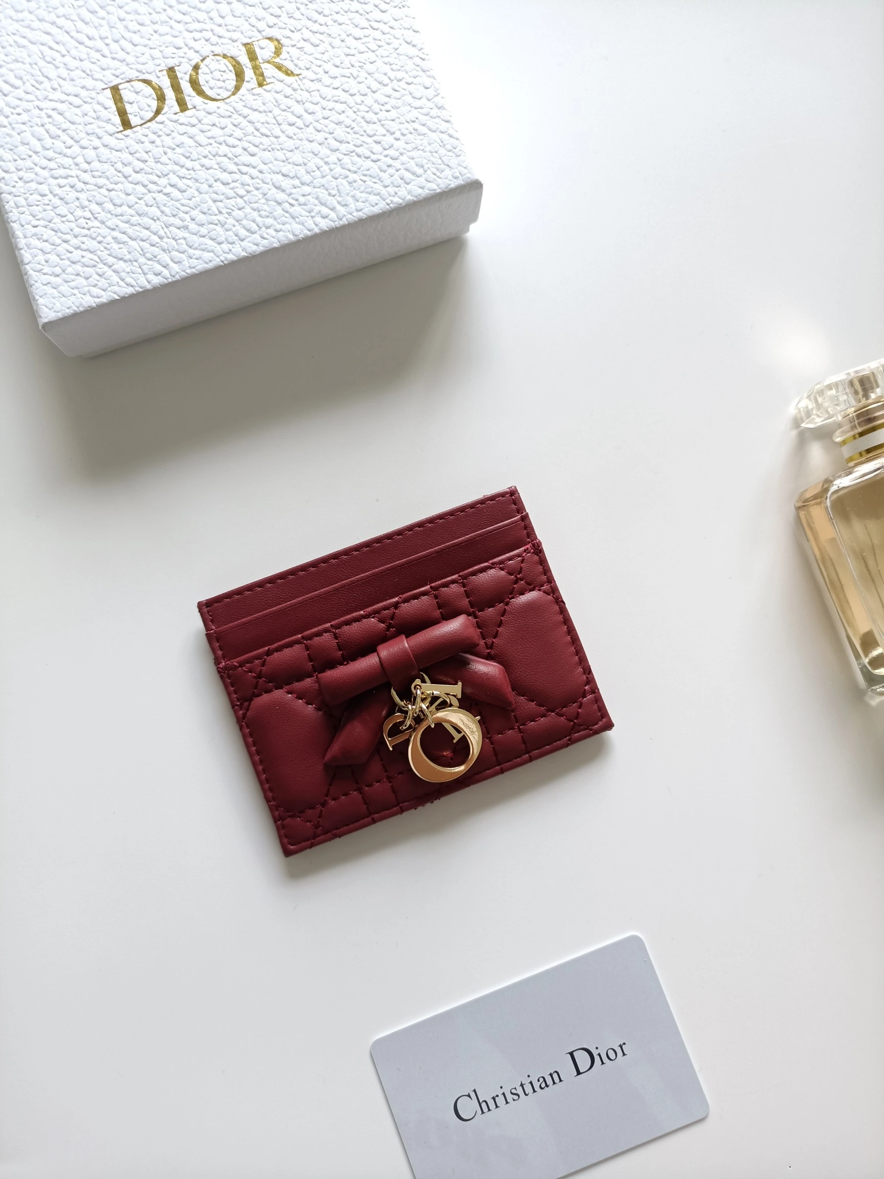 ディオールの最新作、商品番号:S2604 サイズ:10.5×8×0.5cm この「Lady Dior Freesia」カードケースは、エレガントで実用的なアクセサリーです。淡いピンク(Soupir pink)とクリーム色のツートンカラーで、ラムレザーを丁寧に仕立て、カギ目模様のステッチが施されています。前面には装飾用のレザーリボンがアクセントとしてあしらわれ