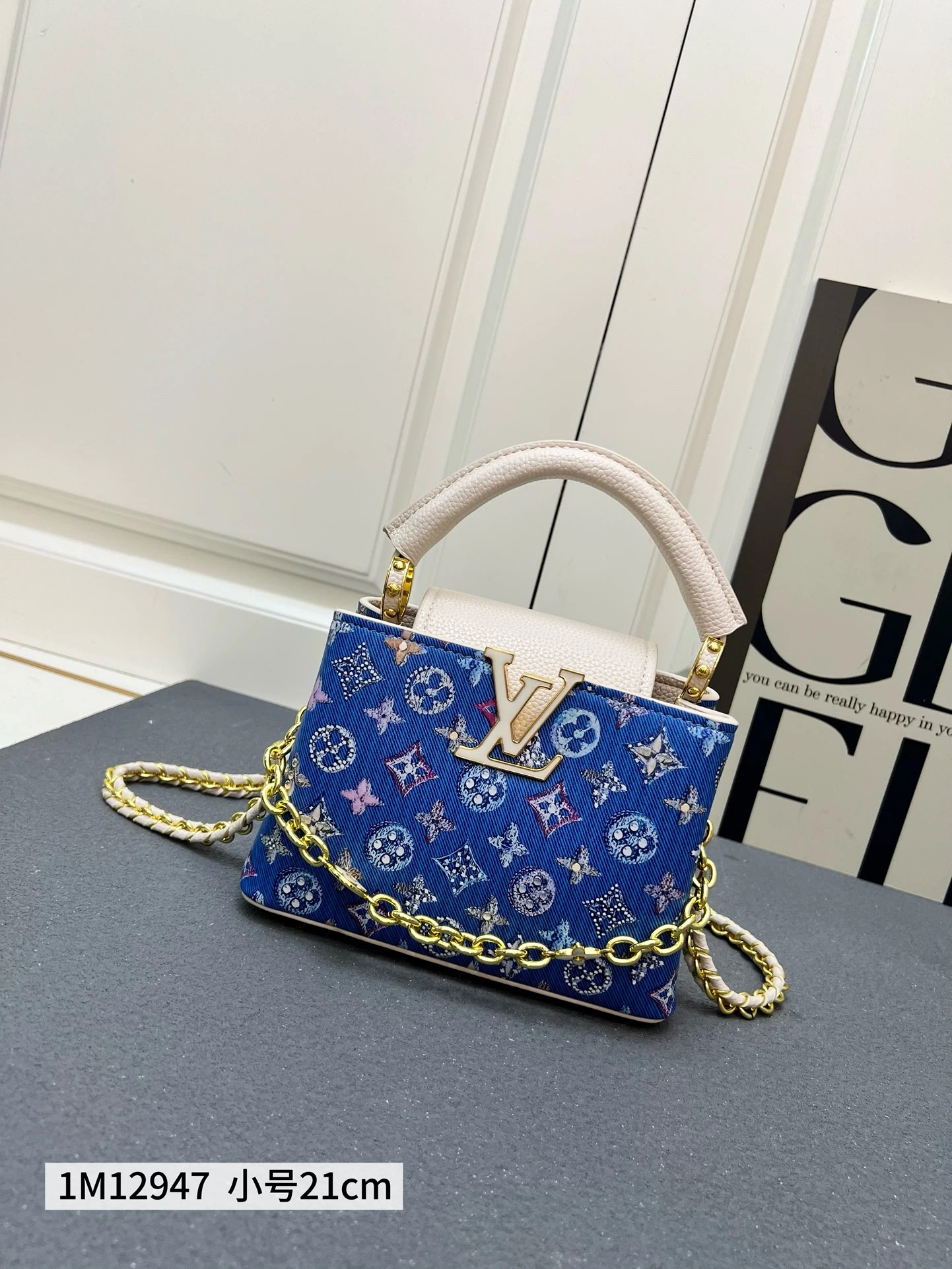 250、カプシーヌ ミニバッグは、モノグラムデニムと刺繍が融合したデザイン。3Dシルクスクリーン LV のアルファベットと編み込みチェーンがメタリックな輝きを放ち、コントラストのあるレザーのトリミングと調和しています。フラップは外側に倒すことも内側に収納することも可能で、整然とした内側構造と多彩な持ち方が機能的なディテールを完成させています。 1M12947
