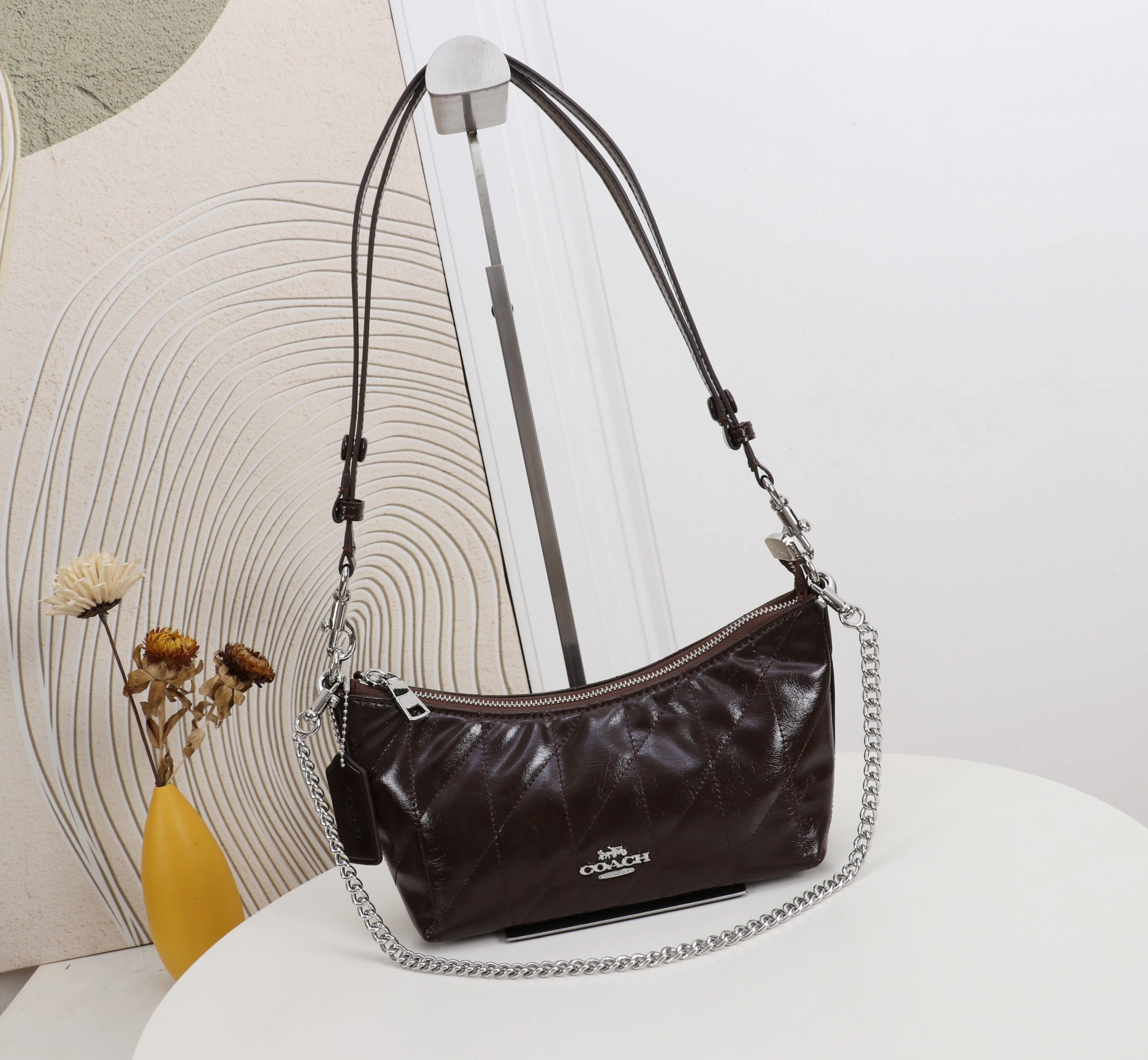 Coach カイトリン(Caitlin)24号シリーズ ショルダーバッグ。小さなチェーンストラップ付きで、手持ちや脇に挟んで持ち運ぶことも可能です。型番:CDZ88 サイズ:24×13×9cm