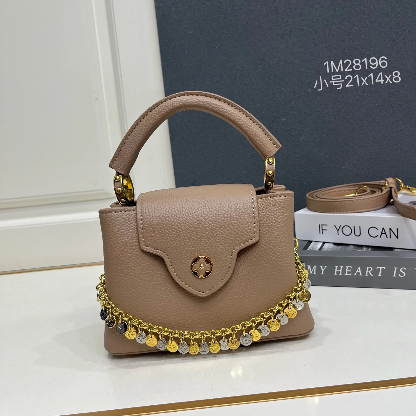 スモールサイズの1M28196「カプシーヌ」ミニバッグは、柔らかな色合いでLV「コンフェッティ」バージョンを表現し、今シーズンのコーディネートに爽やかな雰囲気を添えます。タウリヨン牛革の外装とコントラストカラーの牛革ライニング、艶やかで煌めくメタルが織りなす装飾チェーンが、LVの文字と見事に調和し、内側のポケットには貴重品をしっかりと収納できます。 21 x