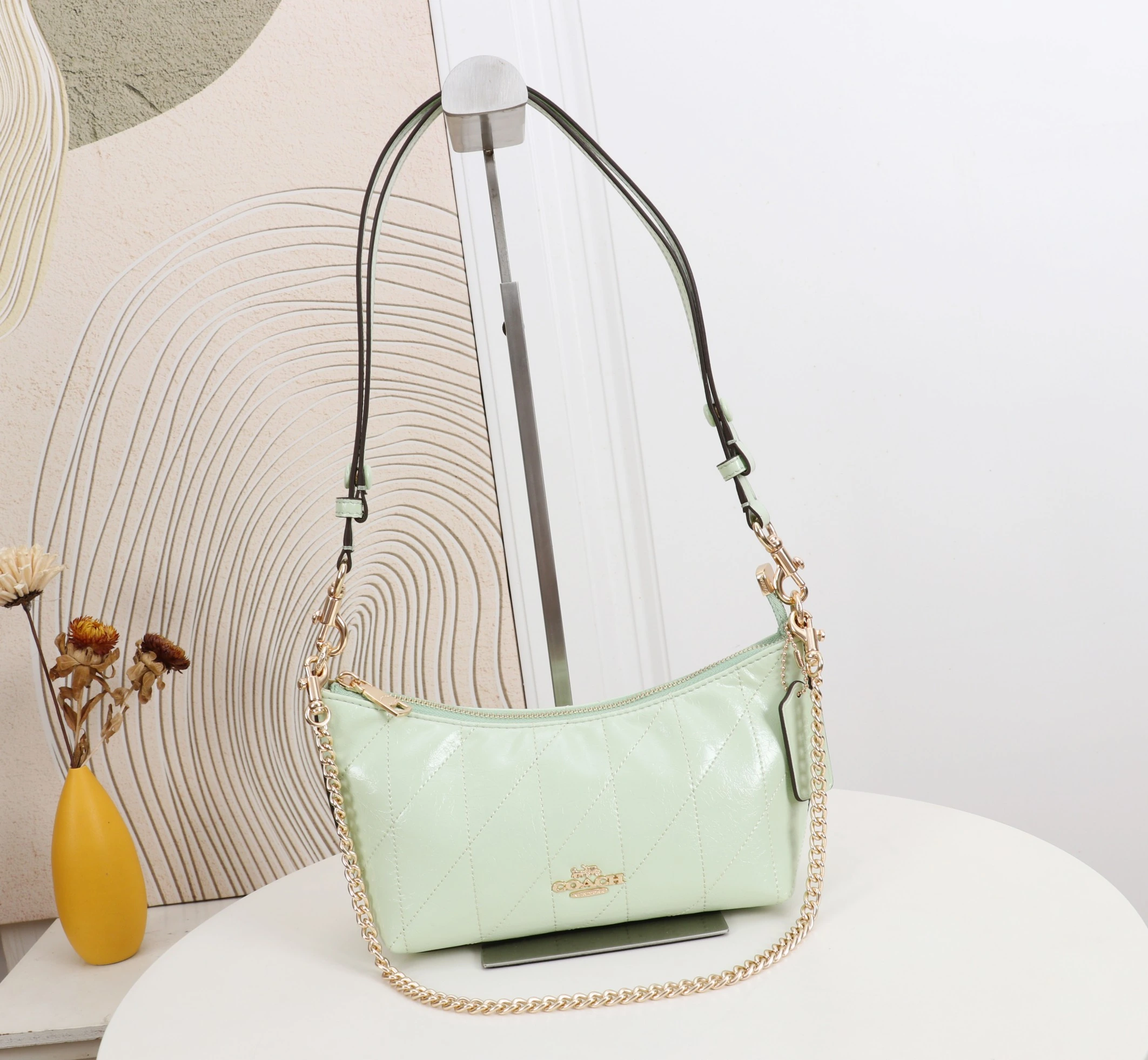 Coach カイトリン(Caitlin)24号シリーズ ショルダーバッグ。小さなチェーンストラップ付きで、手持ちや脇に挟んで持ち運ぶことも可能です。型番:CDZ88 サイズ:24×13×9cm