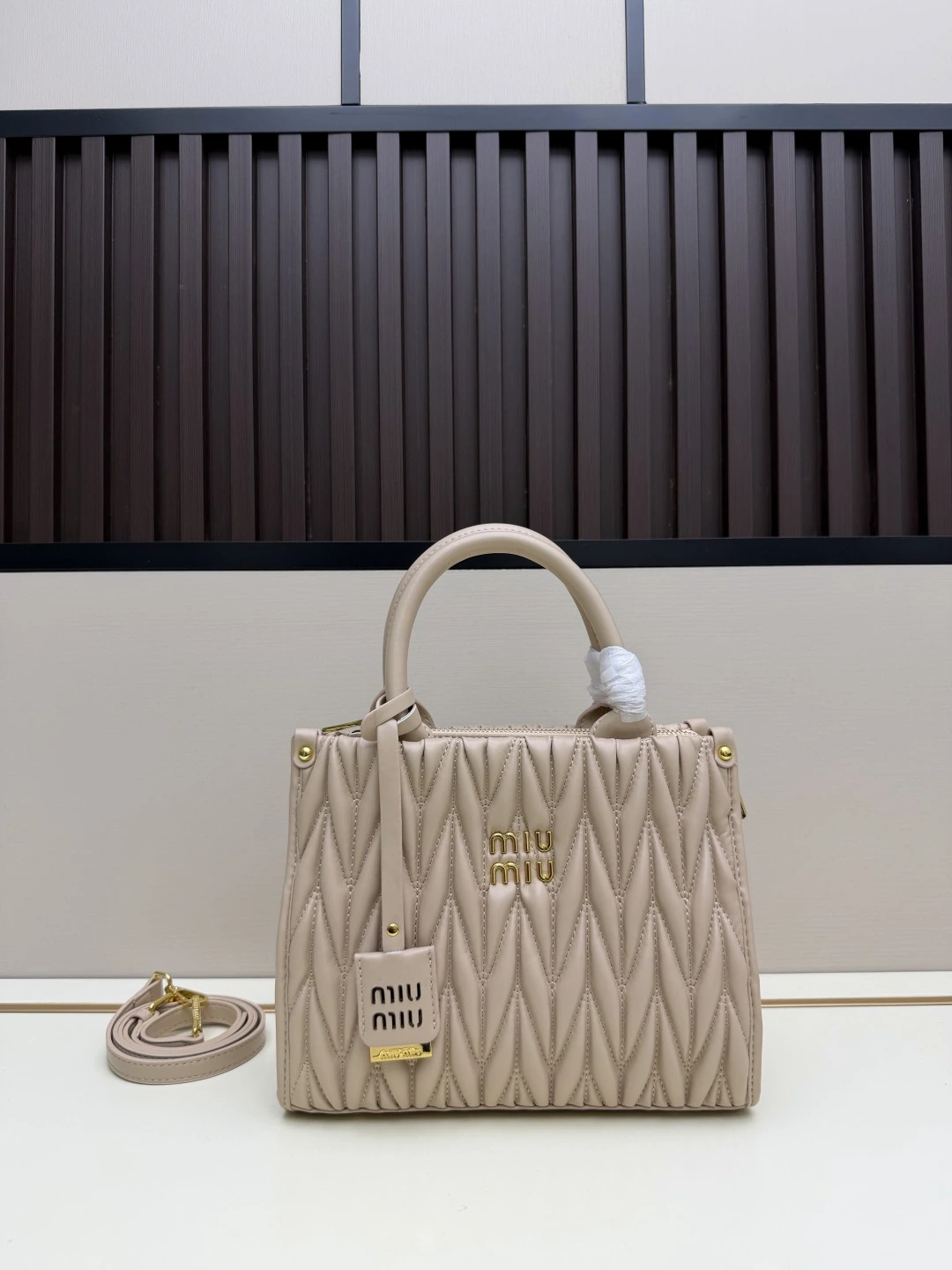 Miu Miu 新作トートバッグ。華やかなマテラッセ技法により、柔らかなラムレザーのトートバッグに活気と汎用性の高い都会的なシルエットを再解釈。バッグ本体に質感豊かな立体的なテクスチャーを与え、レトロなマット仕上げの金具、新しいロゴチャーム、レザーハンドル、取り外し可能なショルダーストラップ、内ポケットが、機能性とモダンさを兼ね備えたデザインを形作っています
