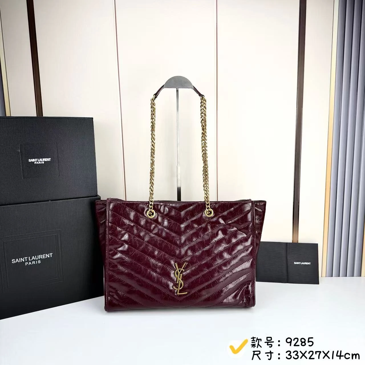 NIKI レトロ風レザーショッピングバッグ レトロな牛革製の横型ショッピングバッグで、LE、CASSANDRE、そしてV字型のステッチがアクセントになっています。軽量で広々としたこのバッグにはチェーンストラップが付いており、ショルダーバッグとしてお使いいただけます。 光沢のあるキルティング加工が施されたボディはすっきりとしたシルエットを演出。チェーンのメタル