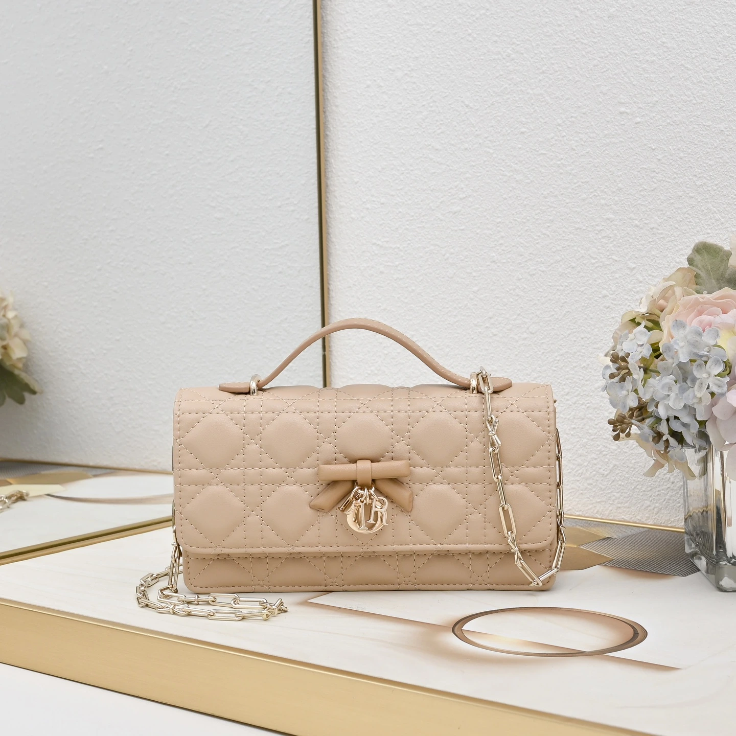 リボン🎀 付きボックス。この「My Dior」ミニチェーンバッグは、エレガントで実用的であり、このシリーズのラインナップをさらに充実させています。オフホワイトとブラックのツートンカラーで、ラムレザーを丁寧に仕立て、ワッフル織りのステッチが施されています。フロントのフラップには装飾的なレザーのリボンが施され、上品な雰囲気を醸し出し、シルバー仕上げのメタル製「D