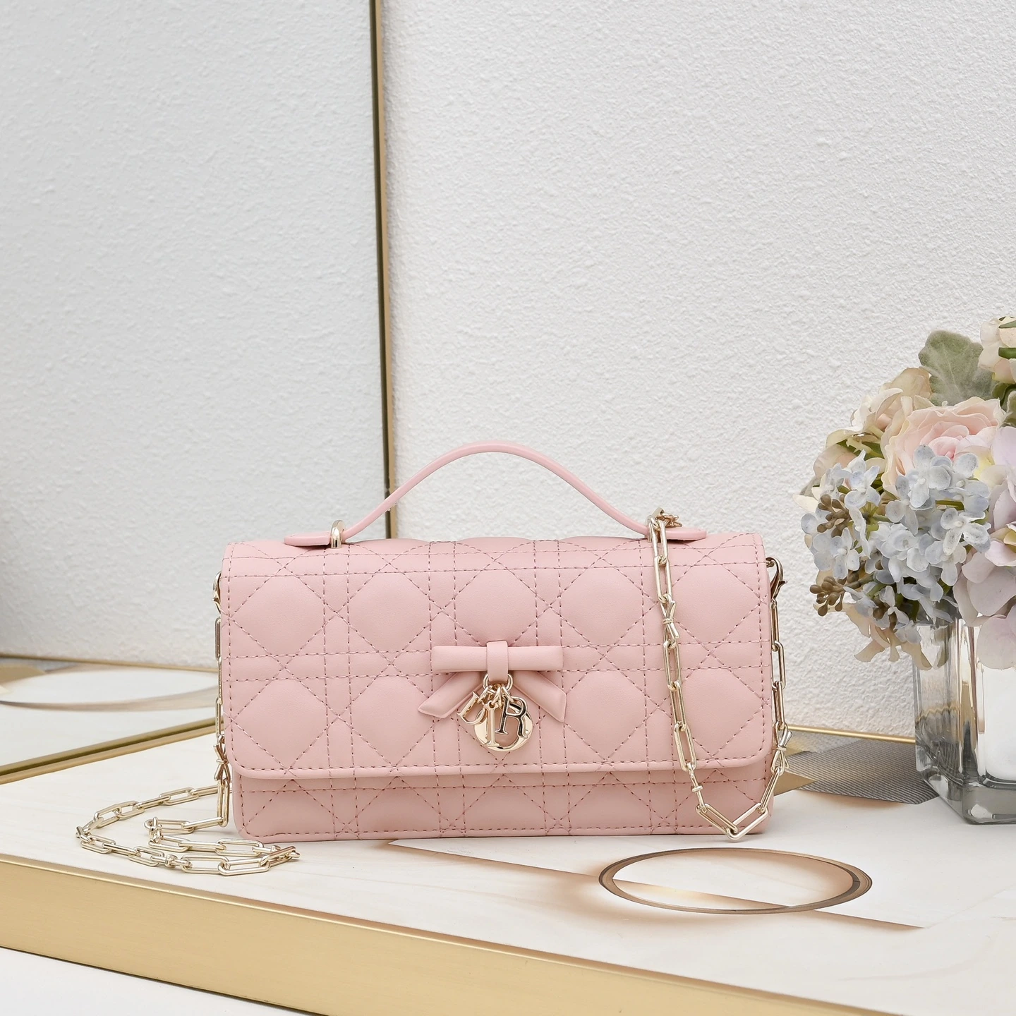 リボン🎀 付きボックス。この「My Dior」ミニチェーンバッグは、エレガントで実用的であり、このシリーズのラインナップをさらに充実させています。オフホワイトとブラックのツートンカラーで、ラムレザーを丁寧に仕立て、ワッフル織りのステッチが施されています。フロントのフラップには装飾的なレザーのリボンが施され、上品な雰囲気を醸し出し、シルバー仕上げのメタル製「D